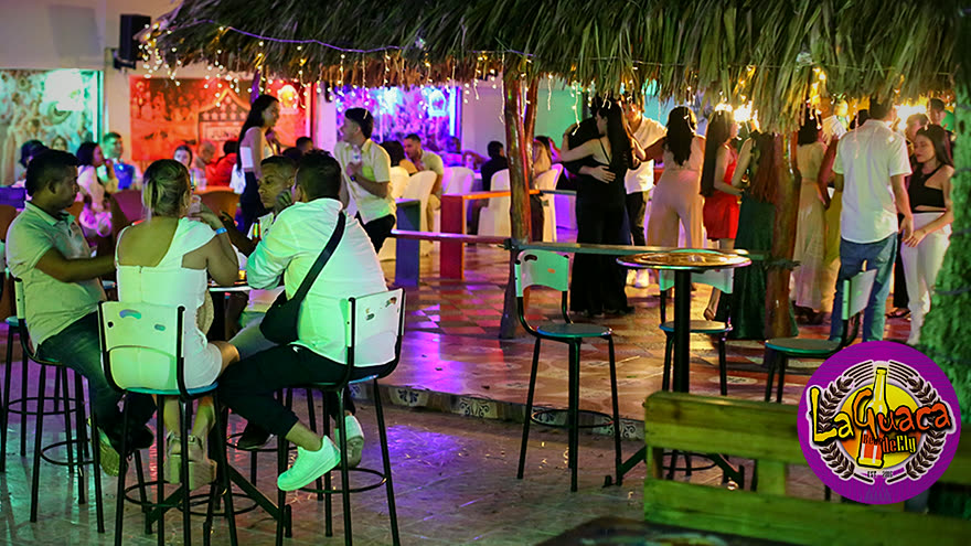 La Guaca de Ely llena de noche, con la palapa iluminada y gente bailando